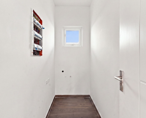 Utility room at Reina Sophia Luca Unit 32 Aruba Reina Sophia Model Luca Unit 32 utility room in Aruba with a small window, white walls, tiled flooring, electrical panel, and utility connections.