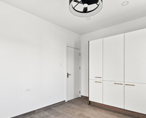 Reina Sophia Model Luca Unit 36 Interior Reina Sophia Model Luca Unit 36 interior in Aruba with white built-in wardrobes, a doorway, tiled flooring, and white walls.