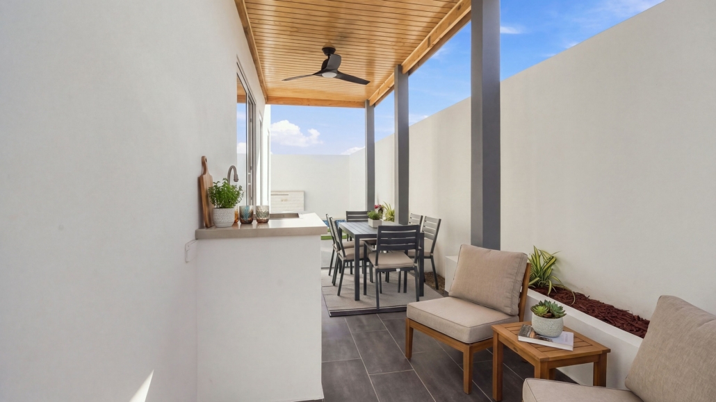 Reina Sophia Model Luca Unit 36 Outdoor Dining Patio in Aruba Covered outdoor dining area at Reina Sophia Model Luca Unit 36 in Aruba with a dining table and chairs, lounge chairs, a counter with sink, tiled floor, and wood ceiling.
